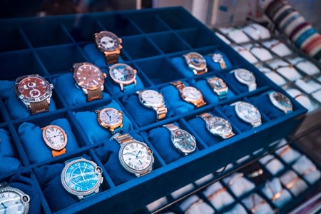 A collection of Cartier watches on display while sitting in a blue case.